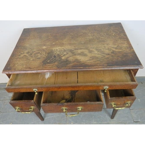 810 - An 18th century oak lowboy, housing one long drawer with brass drop handles, above one long and two ... 