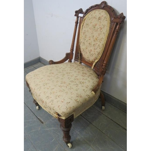 815 - A turn of the century walnut bedroom chair, with carved cornice and reeded uprights, upholstered in ... 