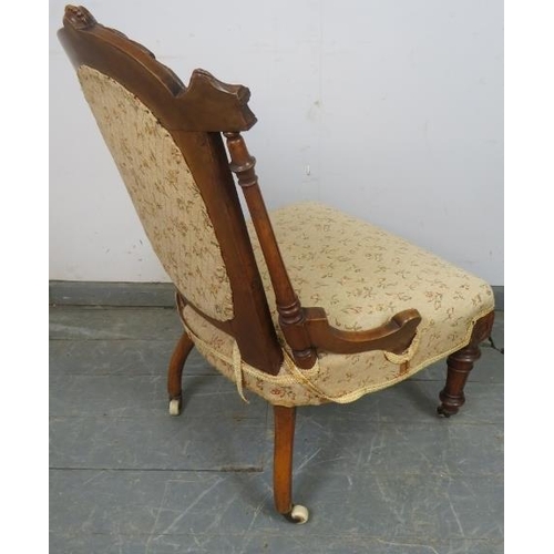 815 - A turn of the century walnut bedroom chair, with carved cornice and reeded uprights, upholstered in ... 