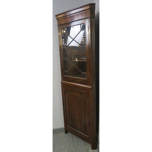 817 - A tall Edwardian Georgian Revival corner cupboard, the top with astral glazed door and two fitted sh... 