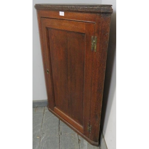 820 - A Georgian oak wall-hanging corner cupboard, with panelled door and three fitted shelves. 
H94cm W62... 