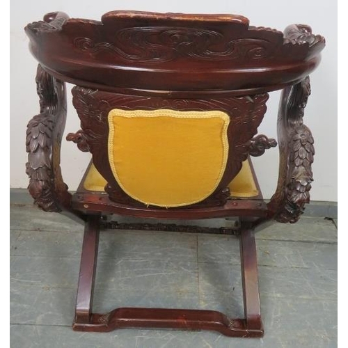 830 - An early 20th century Chinese tropical hardwood folding horseshoe chair, with very ornate carving de... 