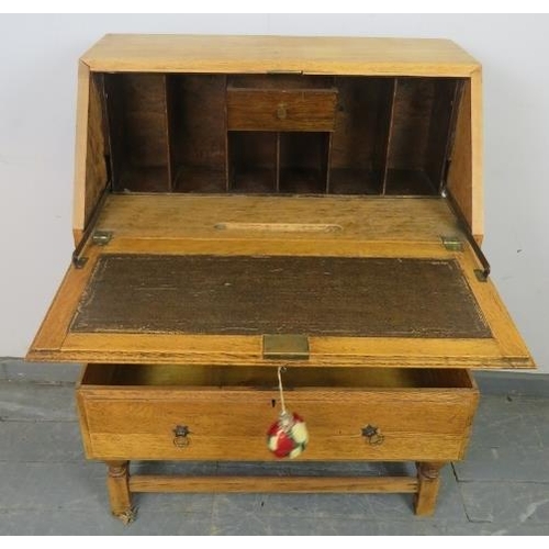 833 - A 1920s light oak bureau, the fall-front opening onto a fitted interior, above two graduated long dr... 