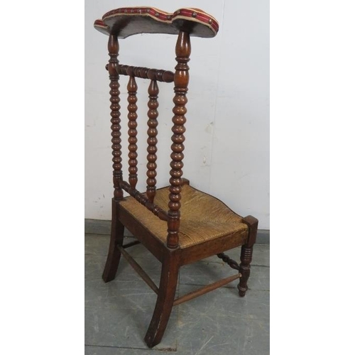 849 - A 19th century Arts & Crafts walnut rush-seated prix-dieux with velvet armrest and ball turned uprig... 