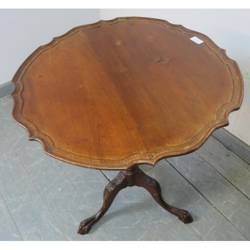 855 - An antique mahogany Georgian Revival tilt-top wine table with pie crust edge, on a tapering and spir... 