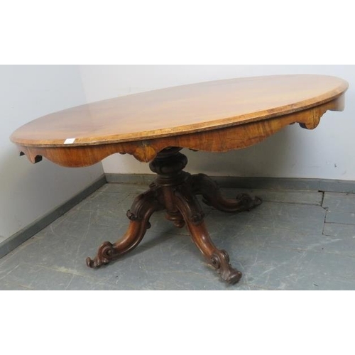 860 - A Victorian walnut oval breakfast table, the quarter veneered top with shaped frieze, on a bulbous c... 