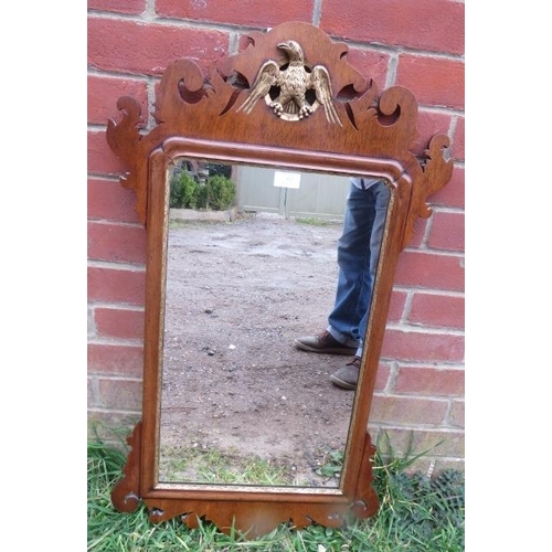 862 - A Georgian mahogany parcel gilt wall mirror in a shaped surround with carved eagle cornice. 
H91cm W... 