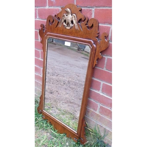 862 - A Georgian mahogany parcel gilt wall mirror in a shaped surround with carved eagle cornice. 
H91cm W... 