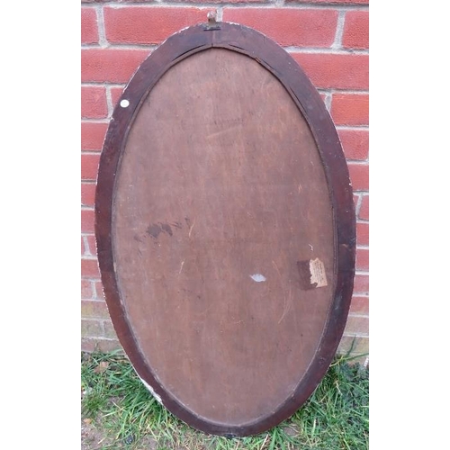 867 - A large Victorian oval bevelled wall mirror in a carved walnut surround.
H103cm W58cm (approx).
Cond... 