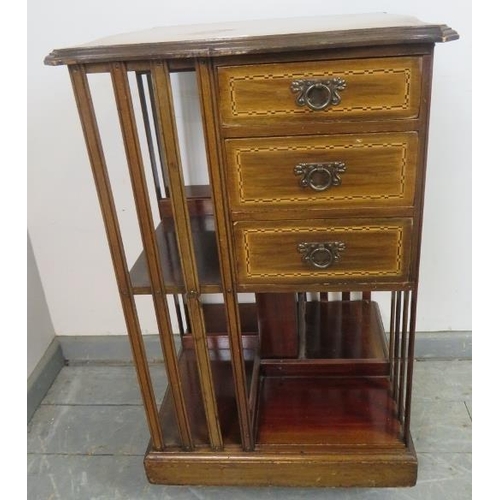 869 - An Edwardian mahogany revolving bookcase, featuring parquetry inlay, with three short drawers and an... 