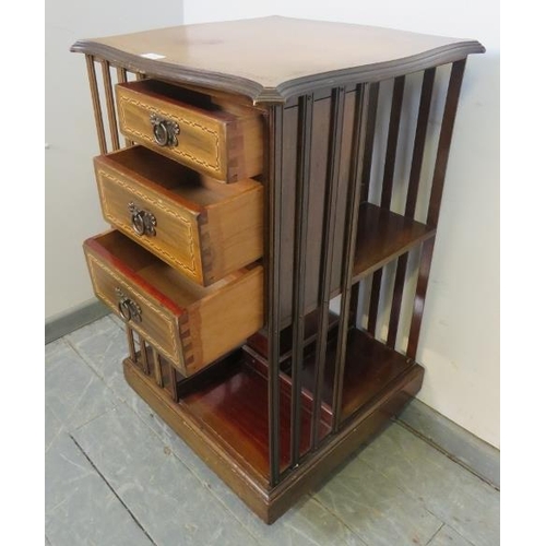 869 - An Edwardian mahogany revolving bookcase, featuring parquetry inlay, with three short drawers and an... 