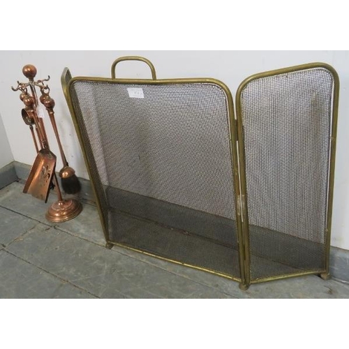 874 - An Edwardian copper and brass fireside companion set, together with a three-section brass and wire m... 