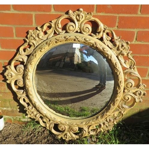 883 - A large convex wall mirror with ornate gesso surround in the Florentine taste, depicting a multitude... 