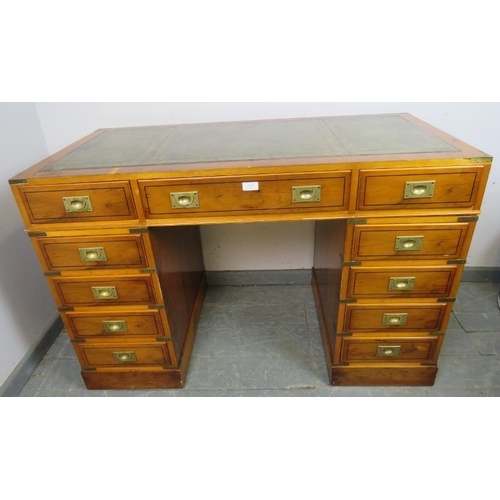 884 - A vintage yew wood and brass bound campaign style pedestal desk, with inset green leather gilt toole... 