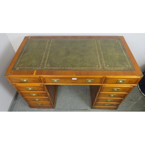 884 - A vintage yew wood and brass bound campaign style pedestal desk, with inset green leather gilt toole... 