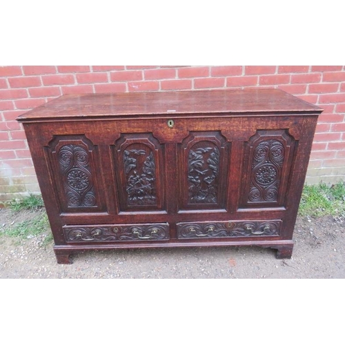 885 - An 18th century oak mule chest, the front with fielded panels featuring relief carved woodland scene... 