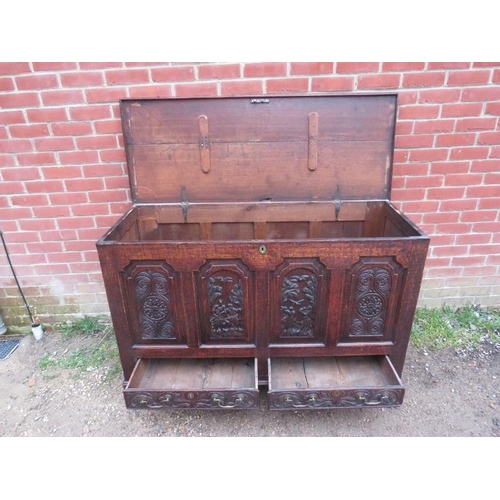 885 - An 18th century oak mule chest, the front with fielded panels featuring relief carved woodland scene... 