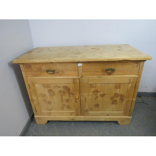 889 - An antique stripped pine sideboard, housing two short drawers above a cupboard with loose shelf, on ... 