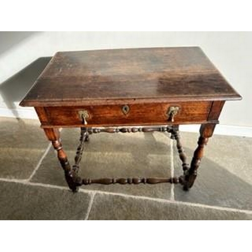 894 - An early 18c Country oak side table (1740 ) with a long frieze drawer and brass drop handles and esc... 