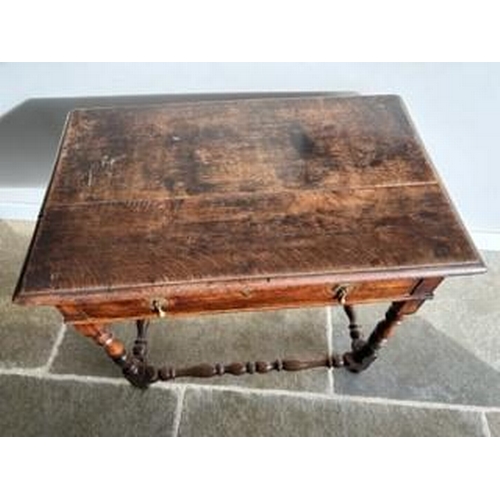 894 - An early 18c Country oak side table (1740 ) with a long frieze drawer and brass drop handles and esc... 