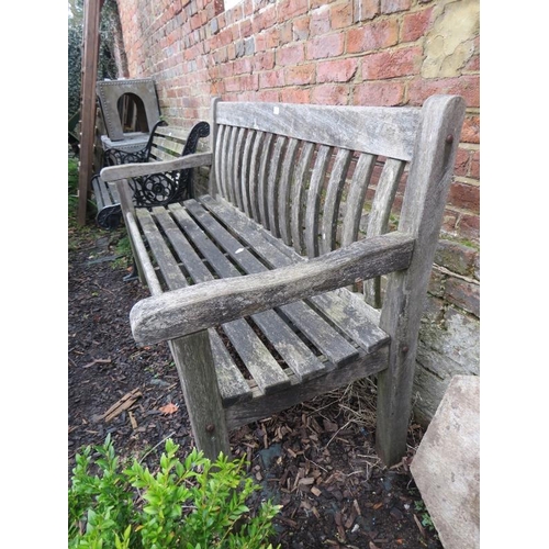 899 - A vintage weathered teak slatted garden bench, on square supports. 
H90cm W154cm D64cm (approx).
Con... 