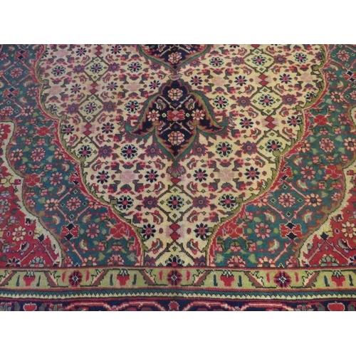 917 - North West Persian Tabriz carpet, beige ground, central motif in reds and blues, reds and edged gree... 