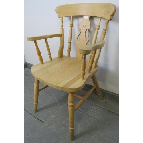 762 - A single beech carver farmhouse kitchen chair with shaped and pierced backsplat and turned spindles,... 