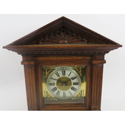 112 - Junghans mantle clock. Architectural oak case, coil strike, with key included. Bevelled glazed doors... 