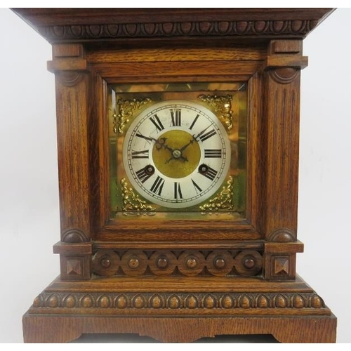 112 - Junghans mantle clock. Architectural oak case, coil strike, with key included. Bevelled glazed doors... 