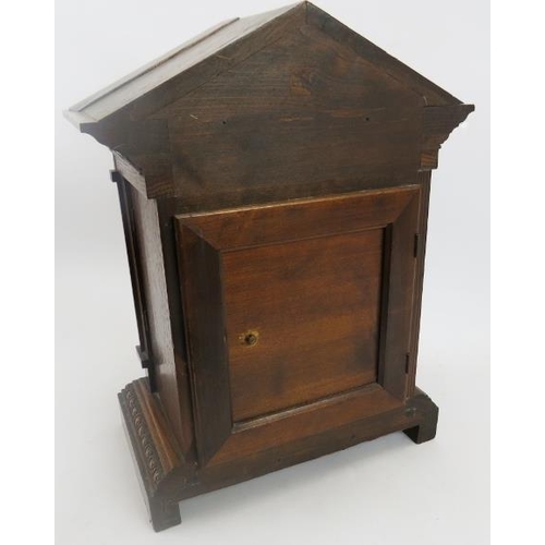 112 - Junghans mantle clock. Architectural oak case, coil strike, with key included. Bevelled glazed doors... 