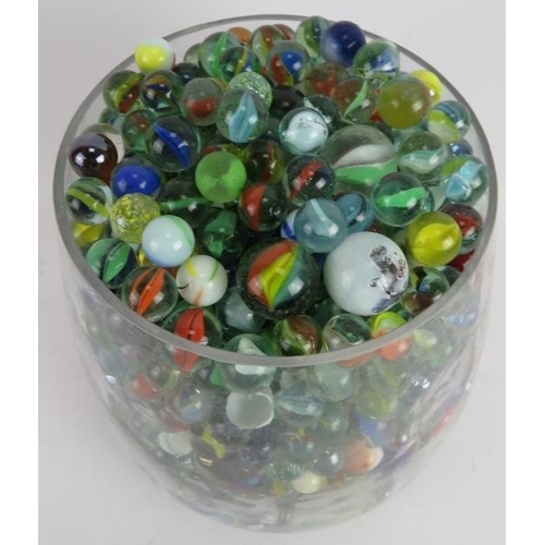 51 - A large quantity of glass marbles of mixed size and colours, collected in a glass vase. Vase: 9.1 in... 