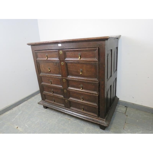 701 - A 17th century and later oak chest housing five graduated drawers with geometric moulding and brass ... 