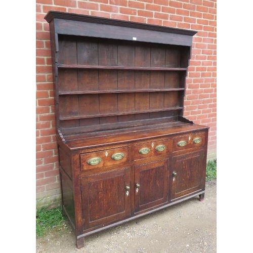 718 - An 18th century oak Welsh dresser with three open shelves over a dresser base housing three short dr... 