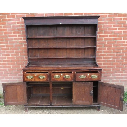 718 - An 18th century oak Welsh dresser with three open shelves over a dresser base housing three short dr... 