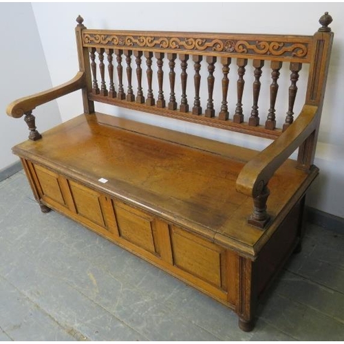 720 - An Arts & Crafts walnut settle by James Shoolbred, with turned ball finials, carved frieze and turne... 