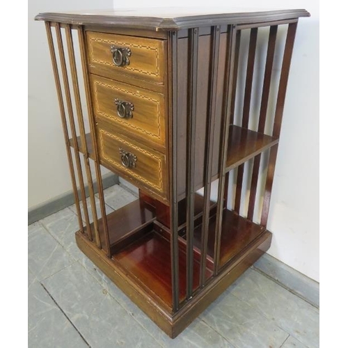 722 - An Edwardian mahogany revolving bookcase, featuring parquetry inlay, with three short drawers and an... 