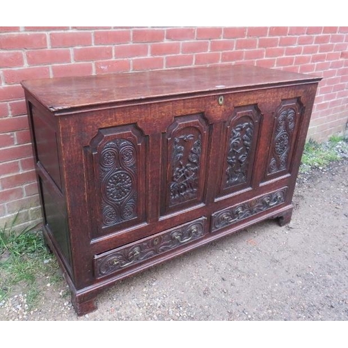 724 - An 18th century oak mule chest, the front with fielded panels featuring relief carved woodland scene... 