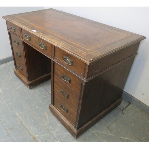 729 - An Edwardian oak pedestal desk, with inset brown leather writing surface, housing a configuration of... 