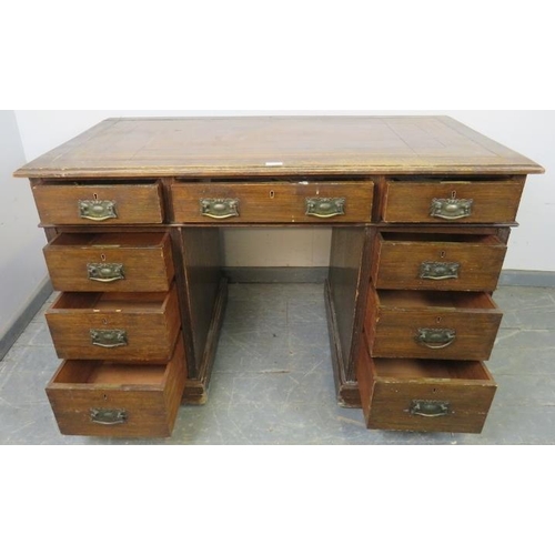 729 - An Edwardian oak pedestal desk, with inset brown leather writing surface, housing a configuration of... 