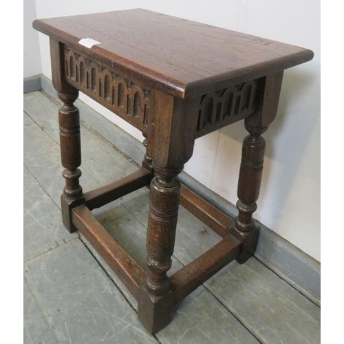 747 - A reproduction oak joint stool in a 16th century taste, with chip carved frieze, on turned supports ... 