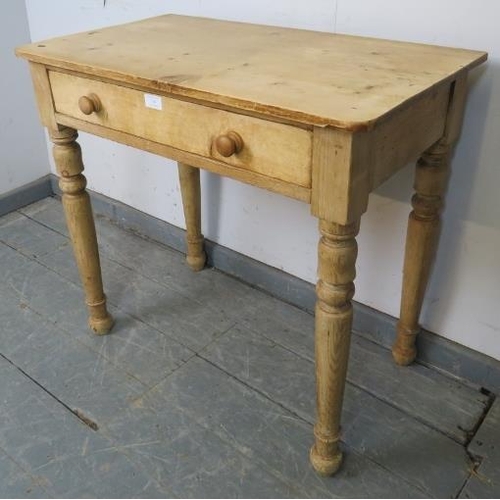 749 - An antique stripped pine side table, housing one long drawer with turned wooden handles, on tapering... 