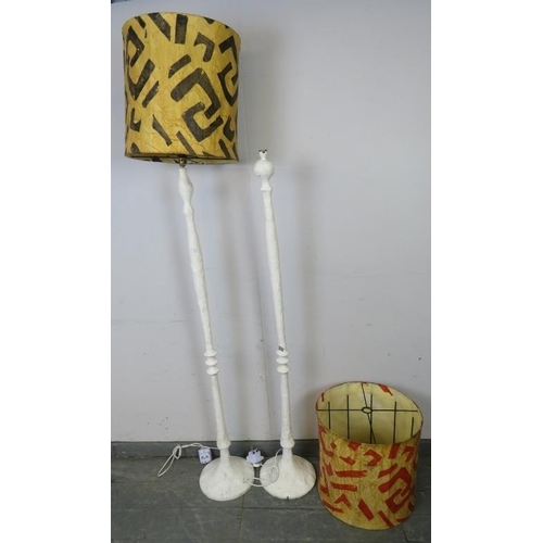 761 - A near pair of freeform cast metal standard lamps painted white, the paper shades with geometric des... 