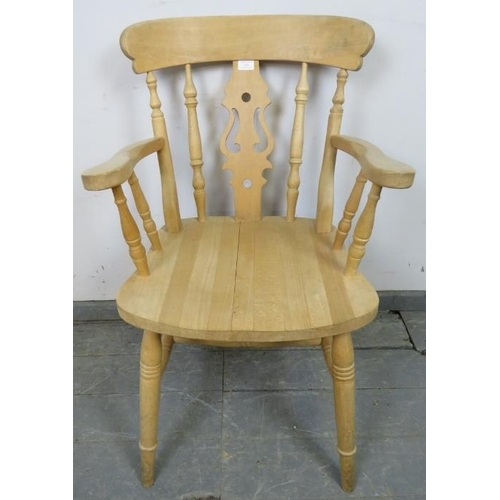 762 - A single beech carver farmhouse kitchen chair with shaped and pierced backsplat and turned spindles,... 