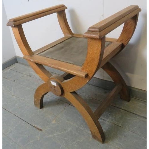 764 - An Arts & Crafts limed oak ‘X-frame’ stool with armrests, on curved supports with side stretchers.
H... 