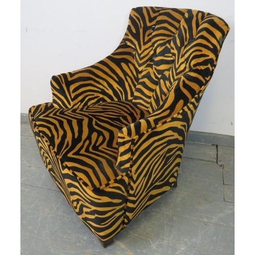 767 - A contemporary armchair, upholstered in buttoned tiger print velvet type material, on tapering squar... 