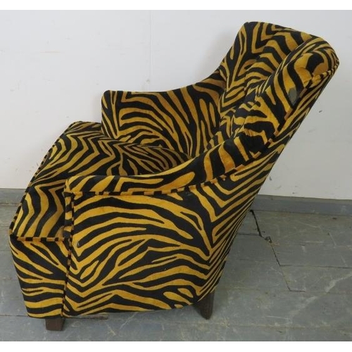 767 - A contemporary armchair, upholstered in buttoned tiger print velvet type material, on tapering squar... 