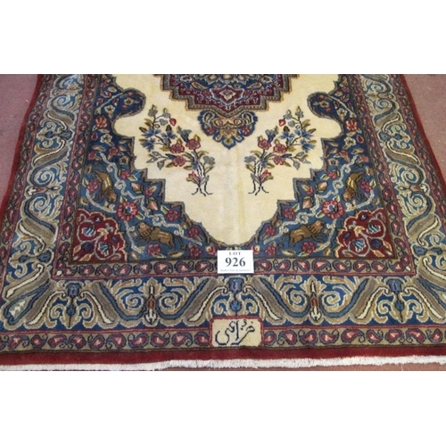 926 - A Persian rug with a central motif, on cream ground and a blue wide border with signature, see image... 