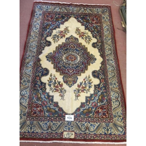 926 - A Persian rug with a central motif, on cream ground and a blue wide border with signature, see image... 