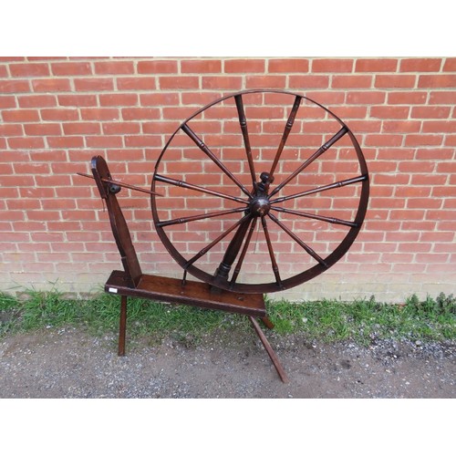 730A - A large 18th century elm spinning wheel, on canted supports. 
Wheel measures 95cm diameter.
Conditio... 