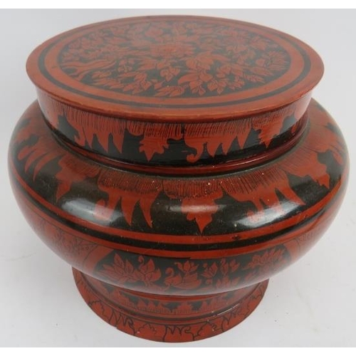 264 - A large Indo Persian red lacquered covered pot. Of baluster form with black hand painted decoration.... 